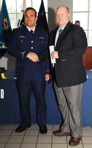 Cadet Stephen Hills (l) receives AFCEA International's annual award for a graduate of the U.S. Coast Guard Academy from Dr. Richard Hartnett, retired U.S. Coast Guard captain, at the graduation ceremony in May.